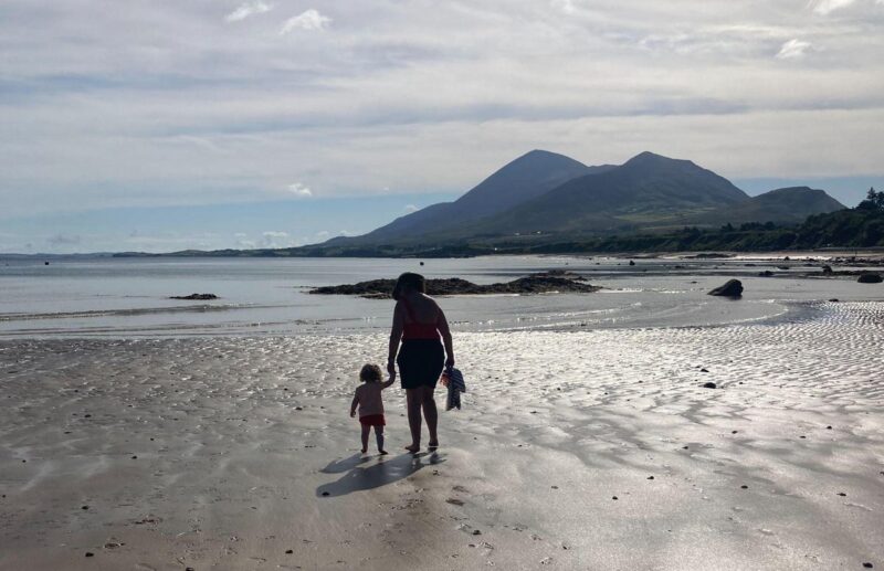 Old Head beach with grandma and toddler walking, Croagh Patrick in the background